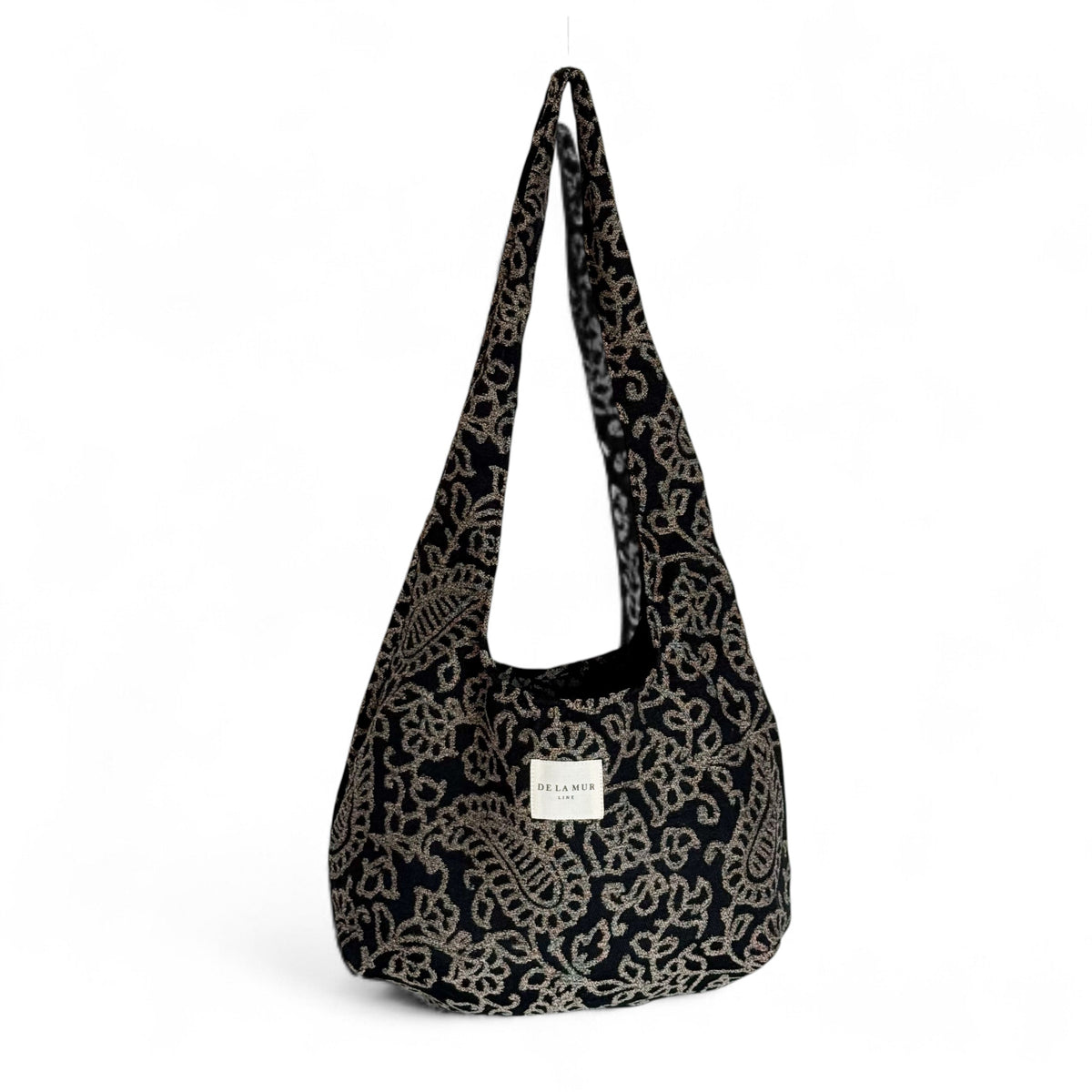DE LA MUR Teide floral jacquard oval shoulder bag in black and beige, front view