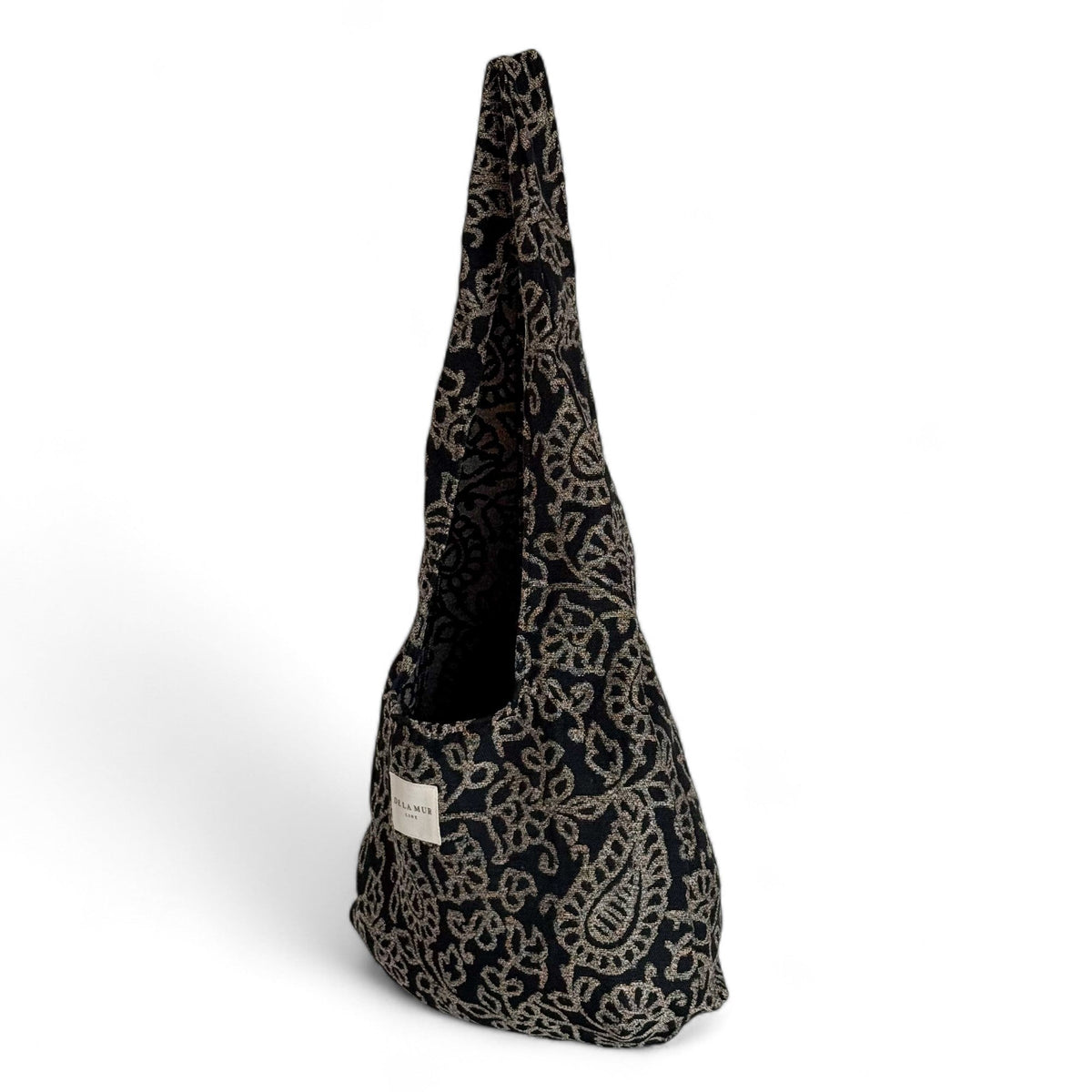 Side view of the DE LA MUR Teide floral jacquard oval bag with long strap