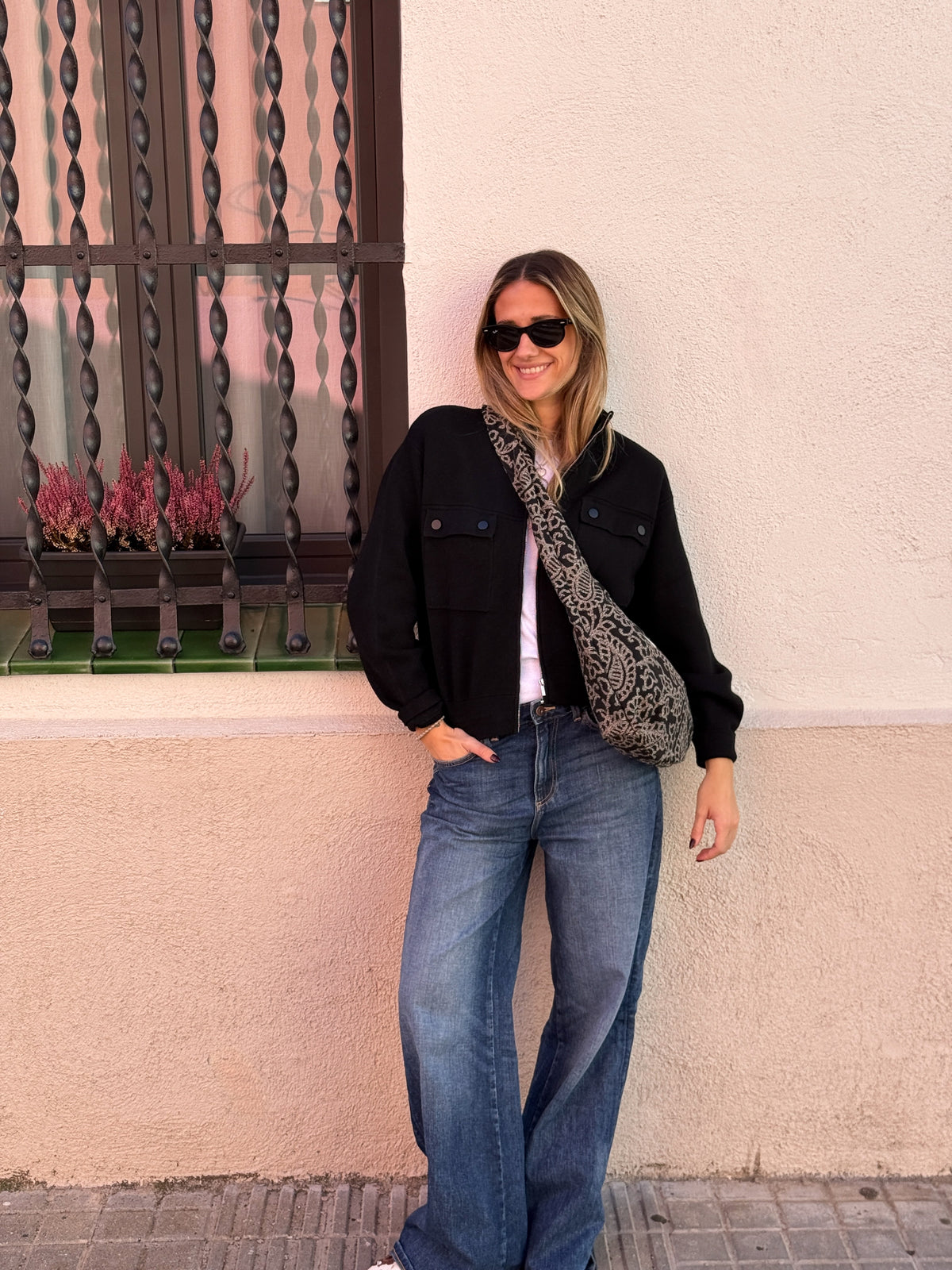 Model wearing the DE LA MUR Teide floral jacquard oval bag crossbody outdoors