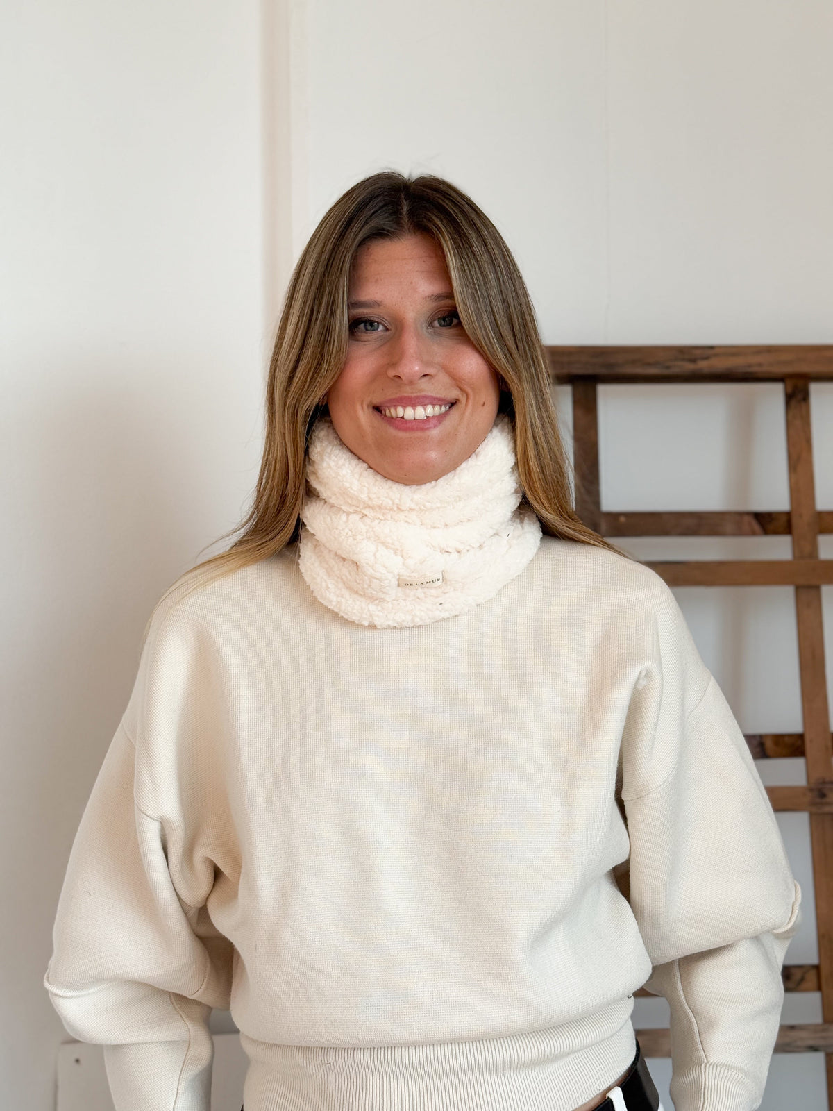 Model wearing the off-white DE LA MUR Frio sherpa neck warmer with cream sweater