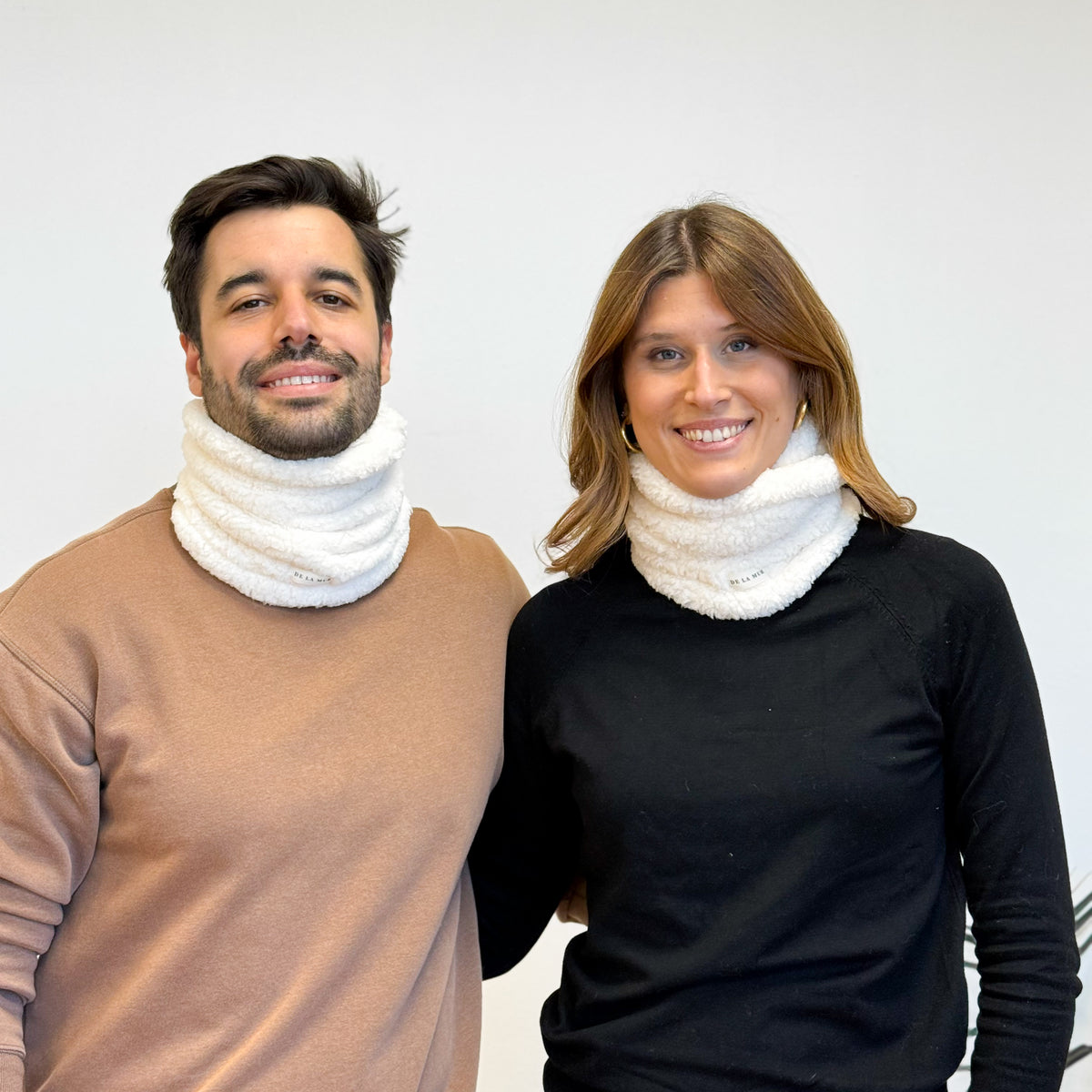 Two models wearing the off-white DE LA MUR Frio sherpa neck warmer, front view