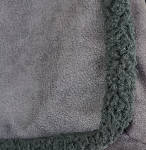 Close-up of the faux suede and dark shearling trim of the DE LA MUR Cene small bag