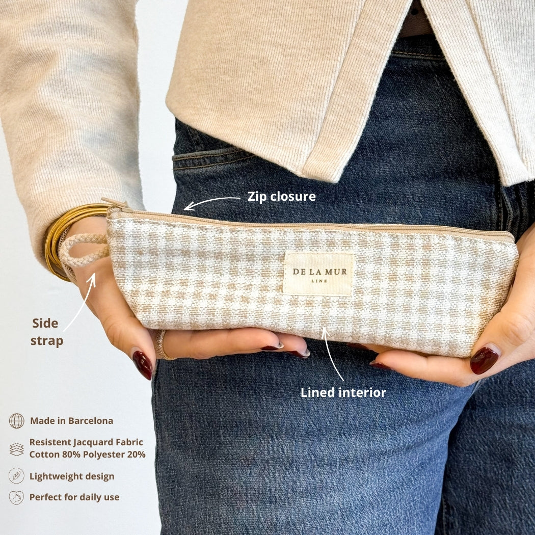 Model holding the DE LA MUR Vison gingham pencil case showing zip closure and side strap