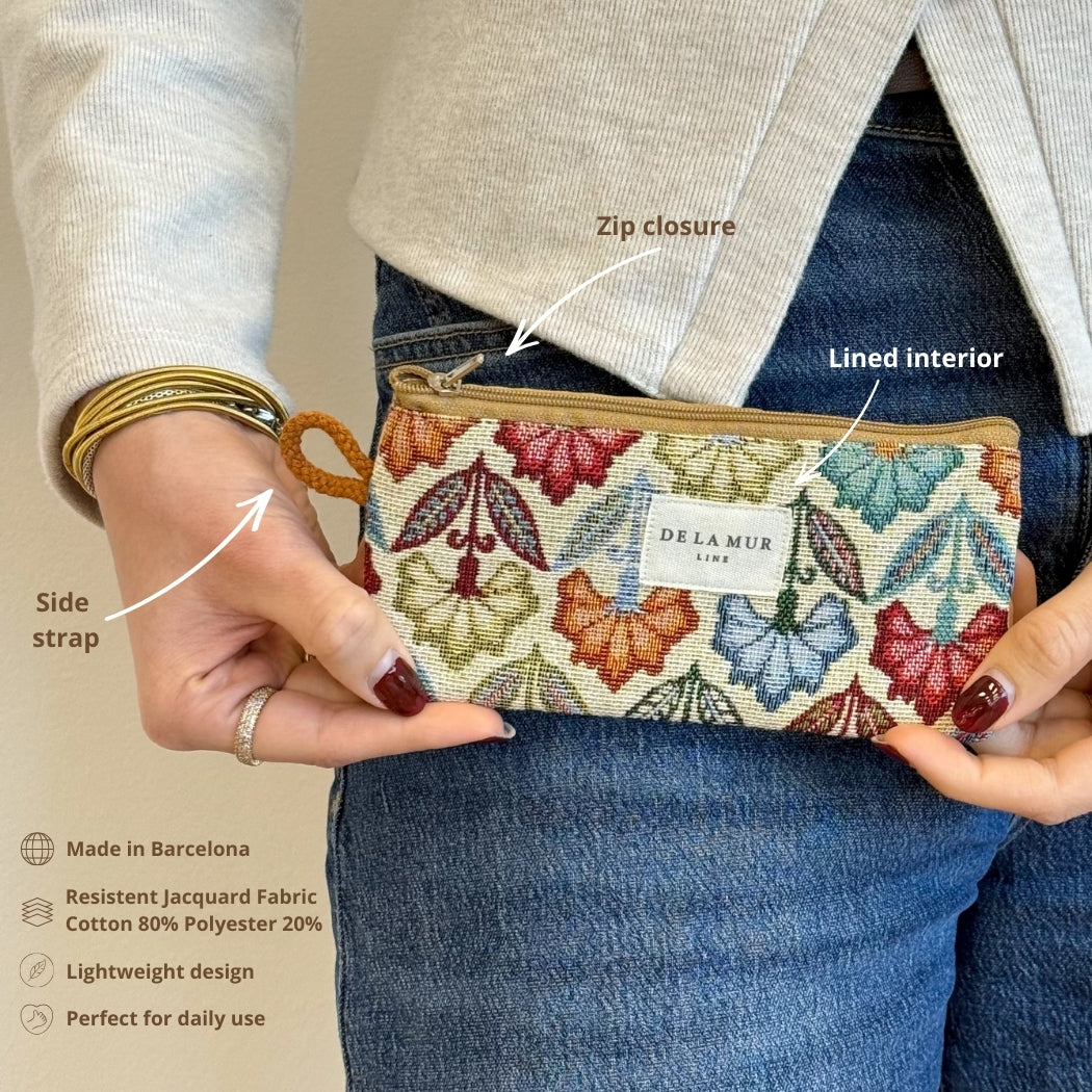 Model holding the DE LA MUR Flora floral eyewear case showing zip closure and side strap