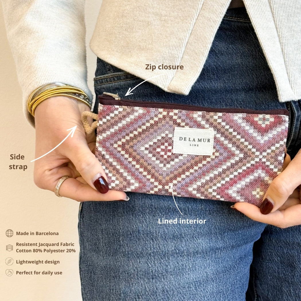 Model holding the DE LA MUR Nana geometric eyewear case showing zip closure and side strap