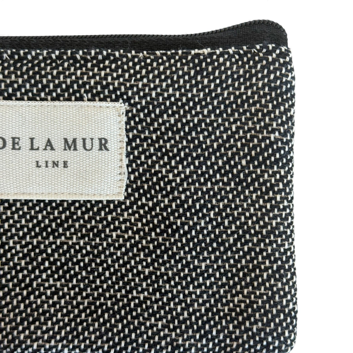 Detail of the DE LA MUR Line label on the Sinay dark gray jacquard case