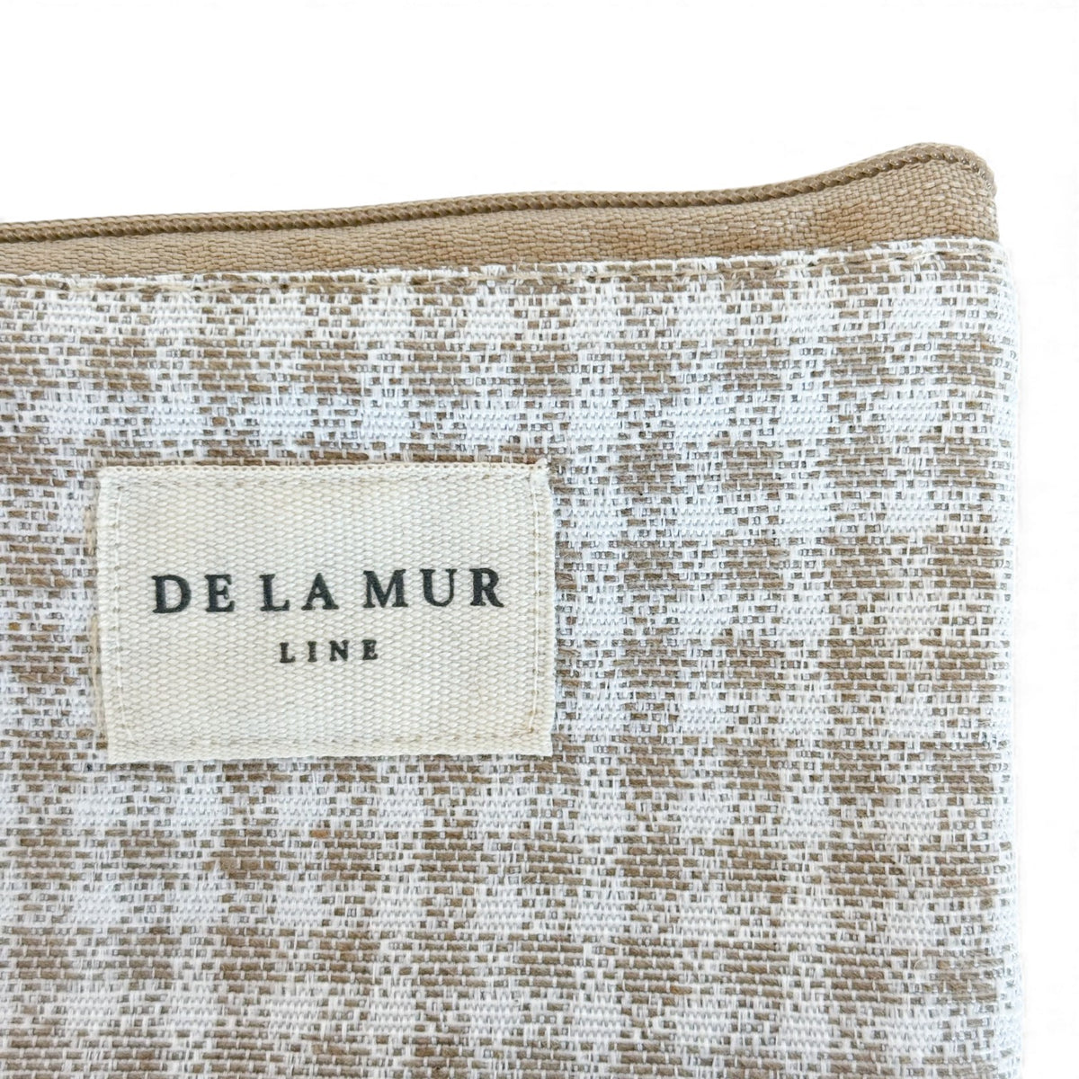 Close-up of the DE LA MUR Line label on the Vison gingham eyewear case