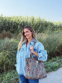 Model carrying the DE LA MUR Trigo geometric jacquard tote bag outdoors