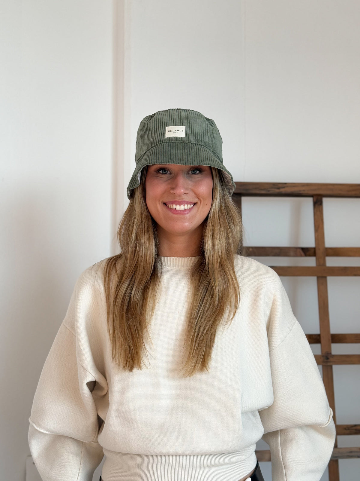 Model wearing the DE LA MUR Tree green corduroy bucket hat, front view