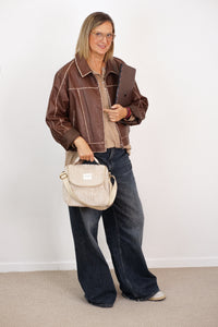Model carrying the DE LA MUR cream beige corduroy lunch bag by its top handle