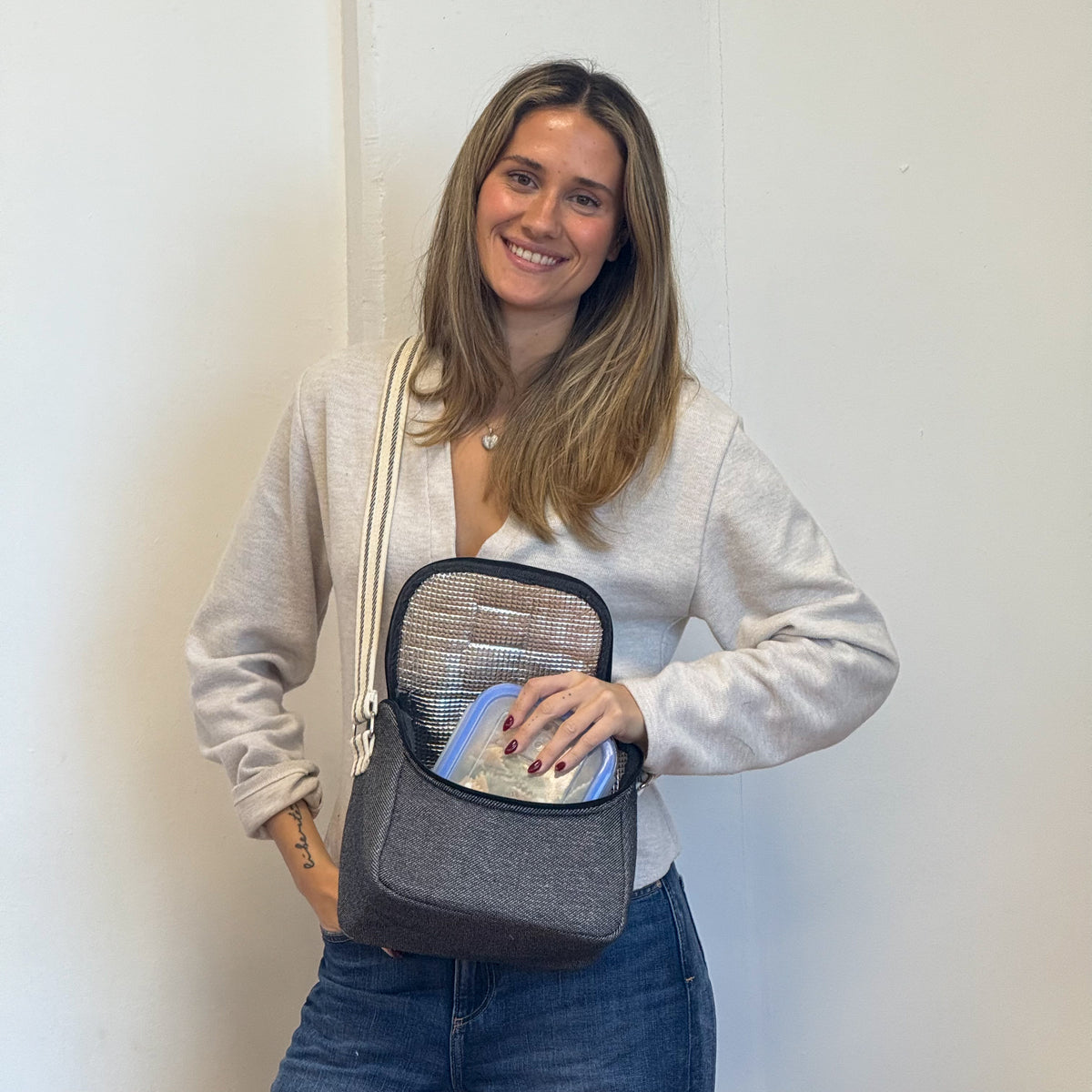 Model placing a food container in the open DE LA MUR Sinay lunch bag