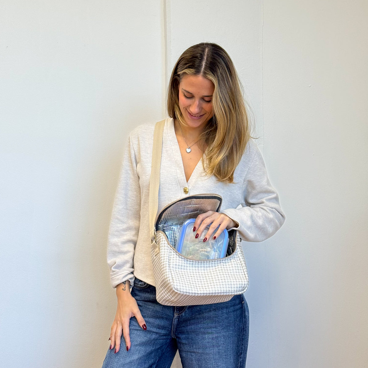 Model placing a food container in the open DE LA MUR Vison lunch bag