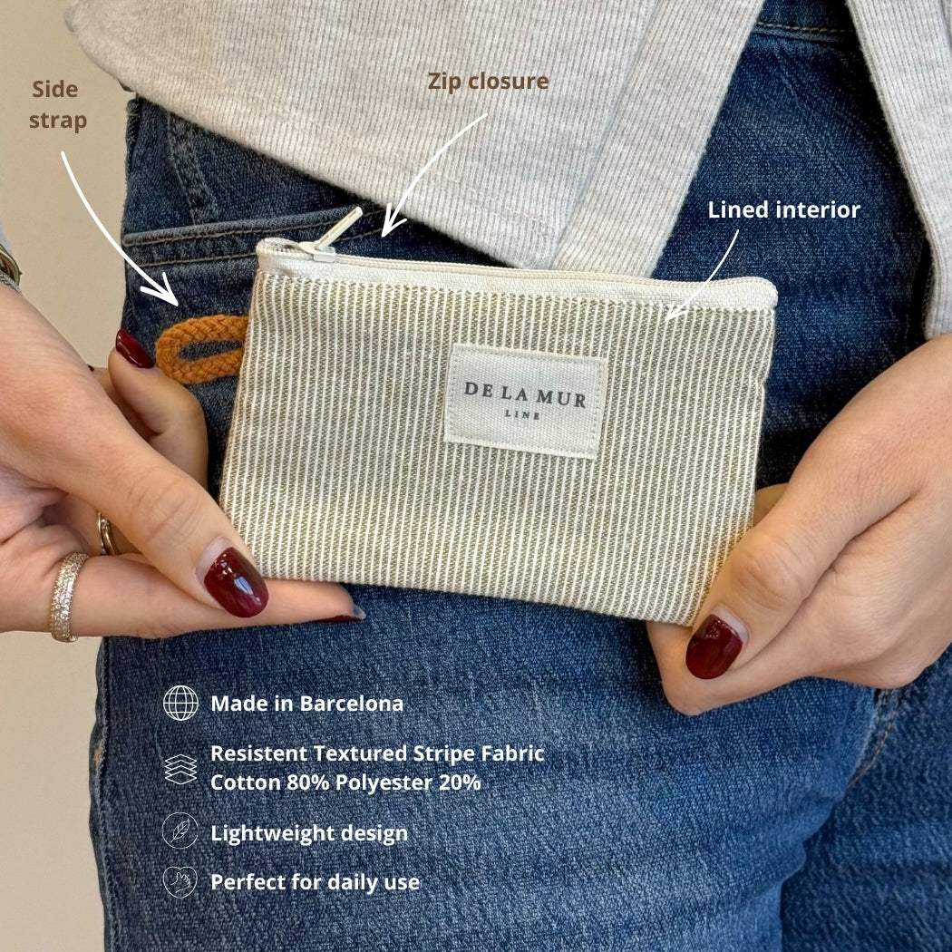 Model holding the DE LA MUR Foz striped coin purse with feature callouts