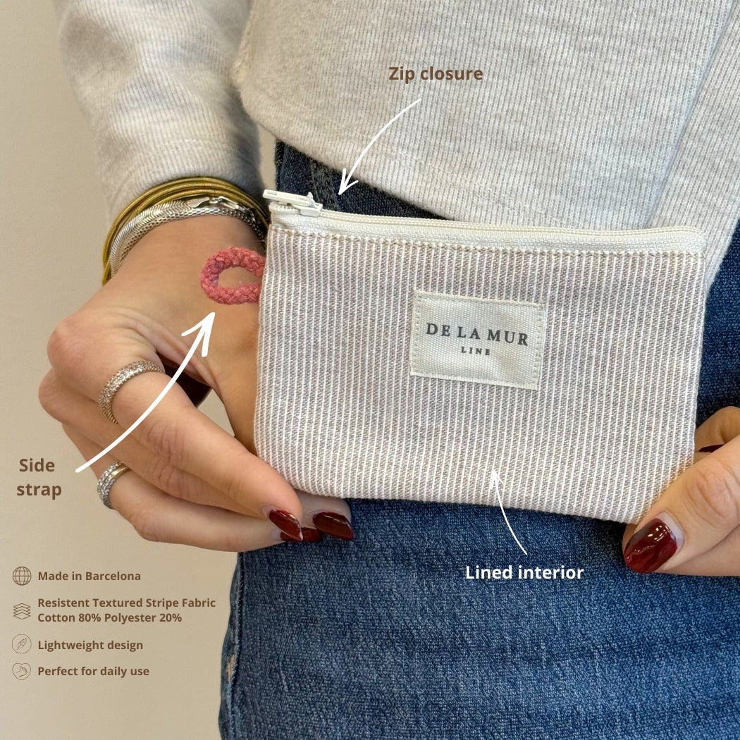 Model holding the DE LA MUR Ibi striped coin purse with feature callouts