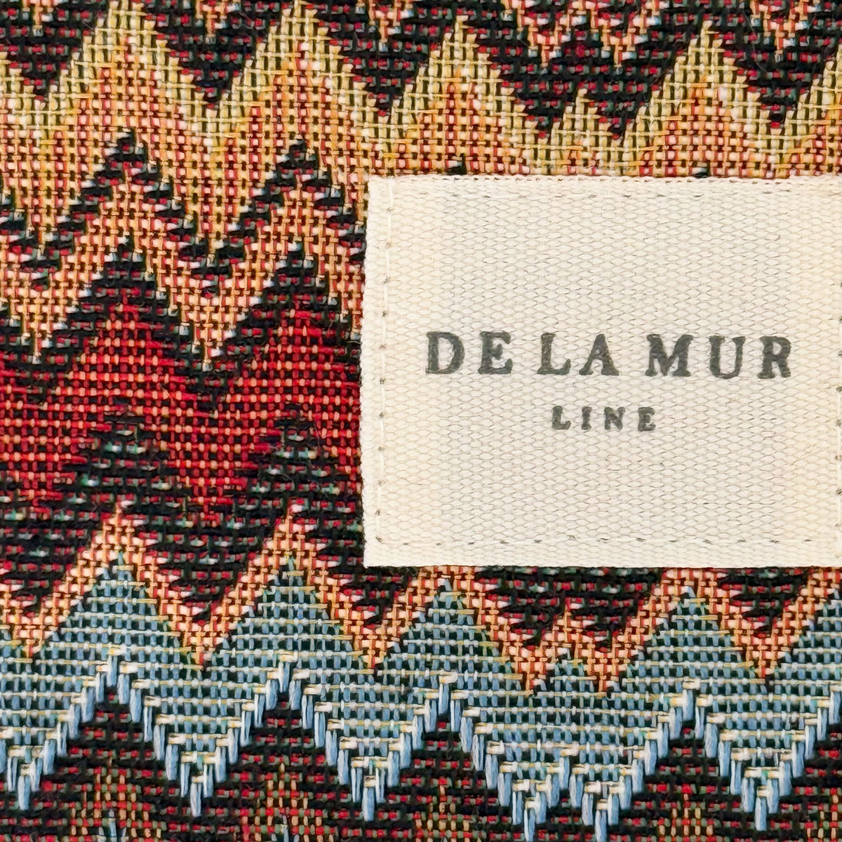 Close-up of the woven zigzag jacquard fabric and DE LA MUR Line label