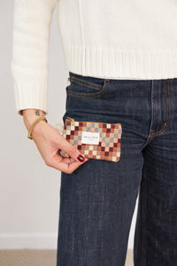 Model holding the DE LA MUR Pier jacquard coin purse by a jeans pocket, lifestyle shot