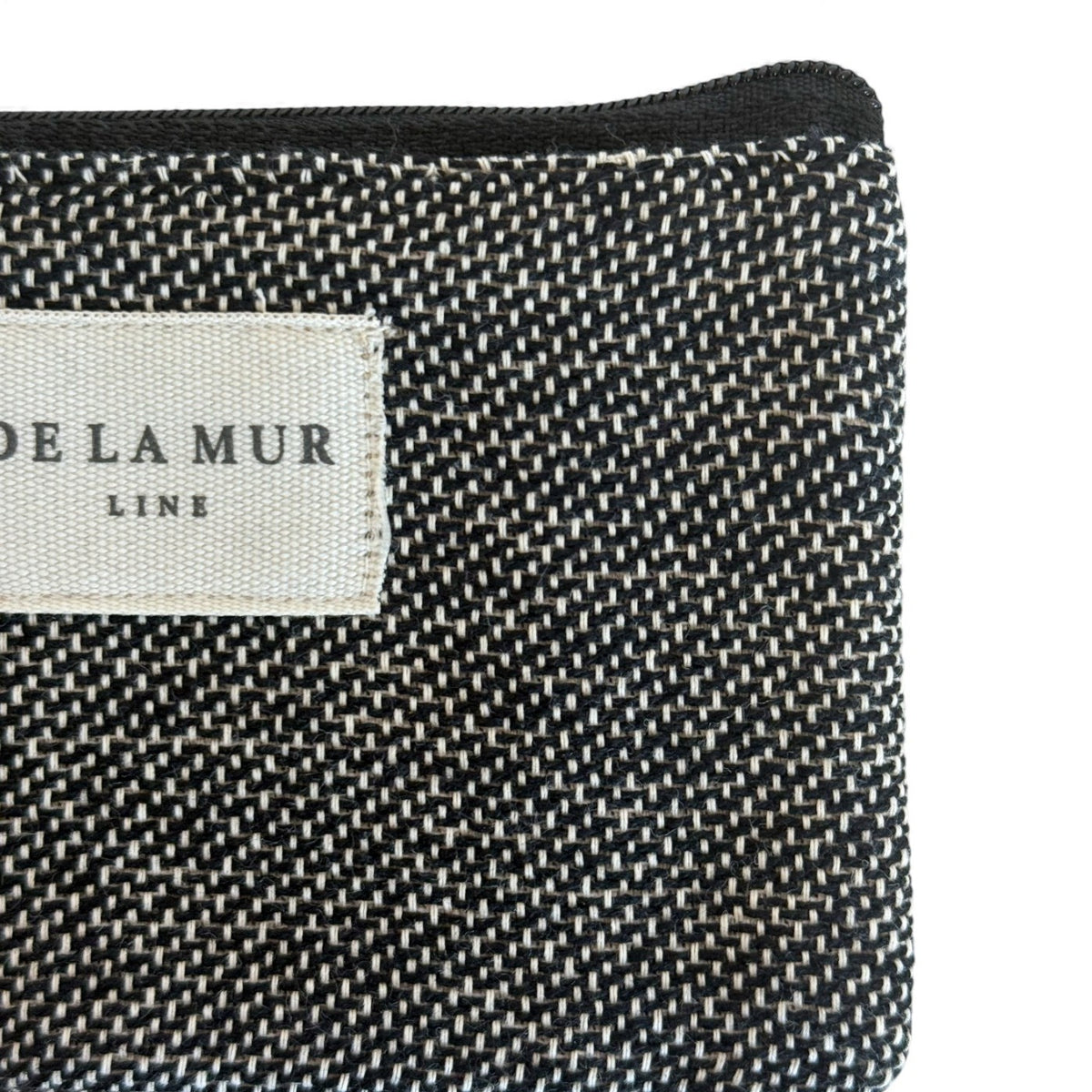 Close-up of DE LA MUR Line label on the Sinay natural and black coin purse