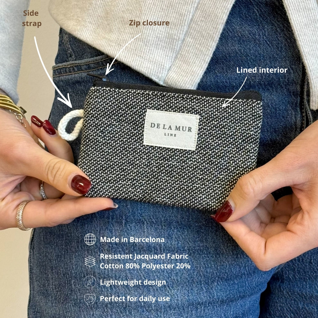 Model holding DE LA MUR Sinay coin purse showing side strap, zip and lined interior