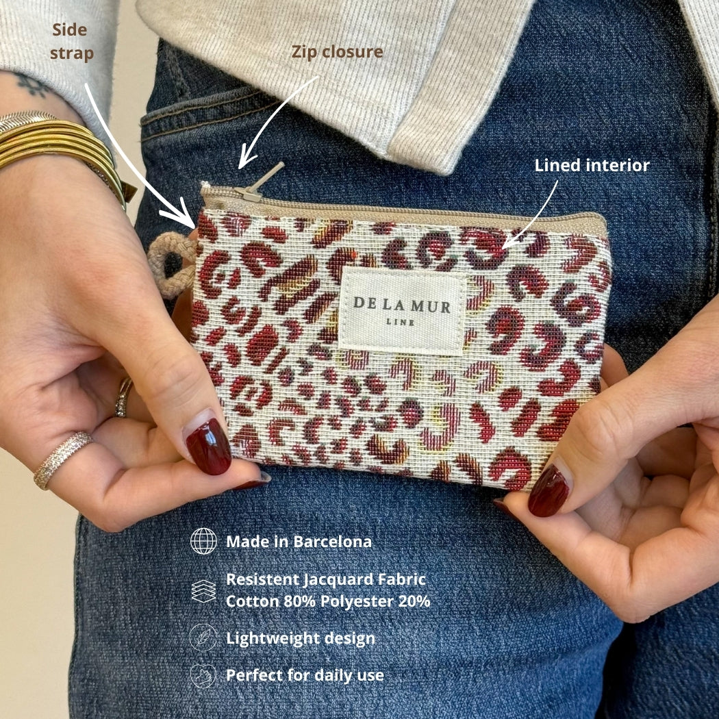 Model holding DE LA MUR Talco leopard coin purse showing side strap and zip closure