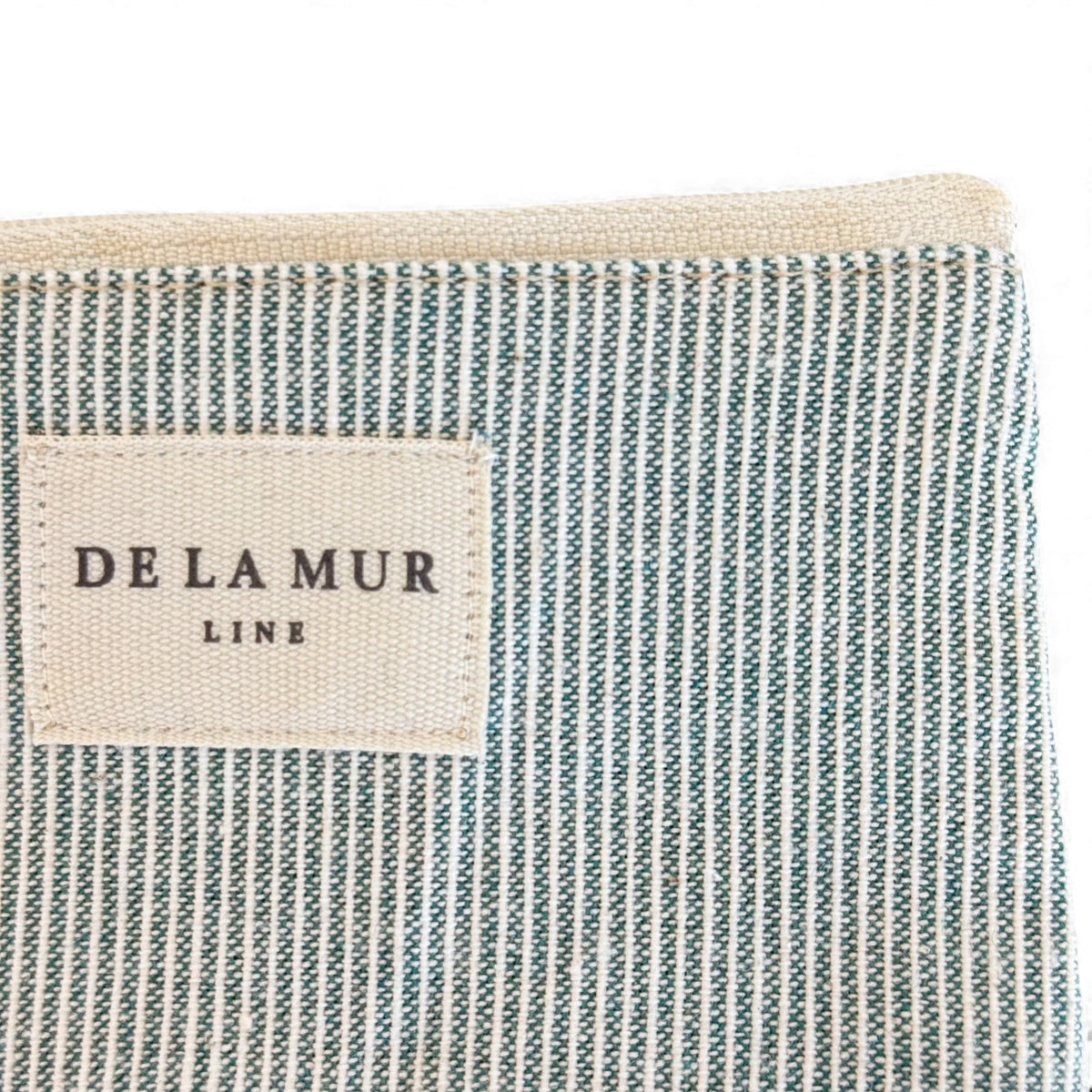 Close-up of DE LA MUR Line label on the Teo green striped coin purse