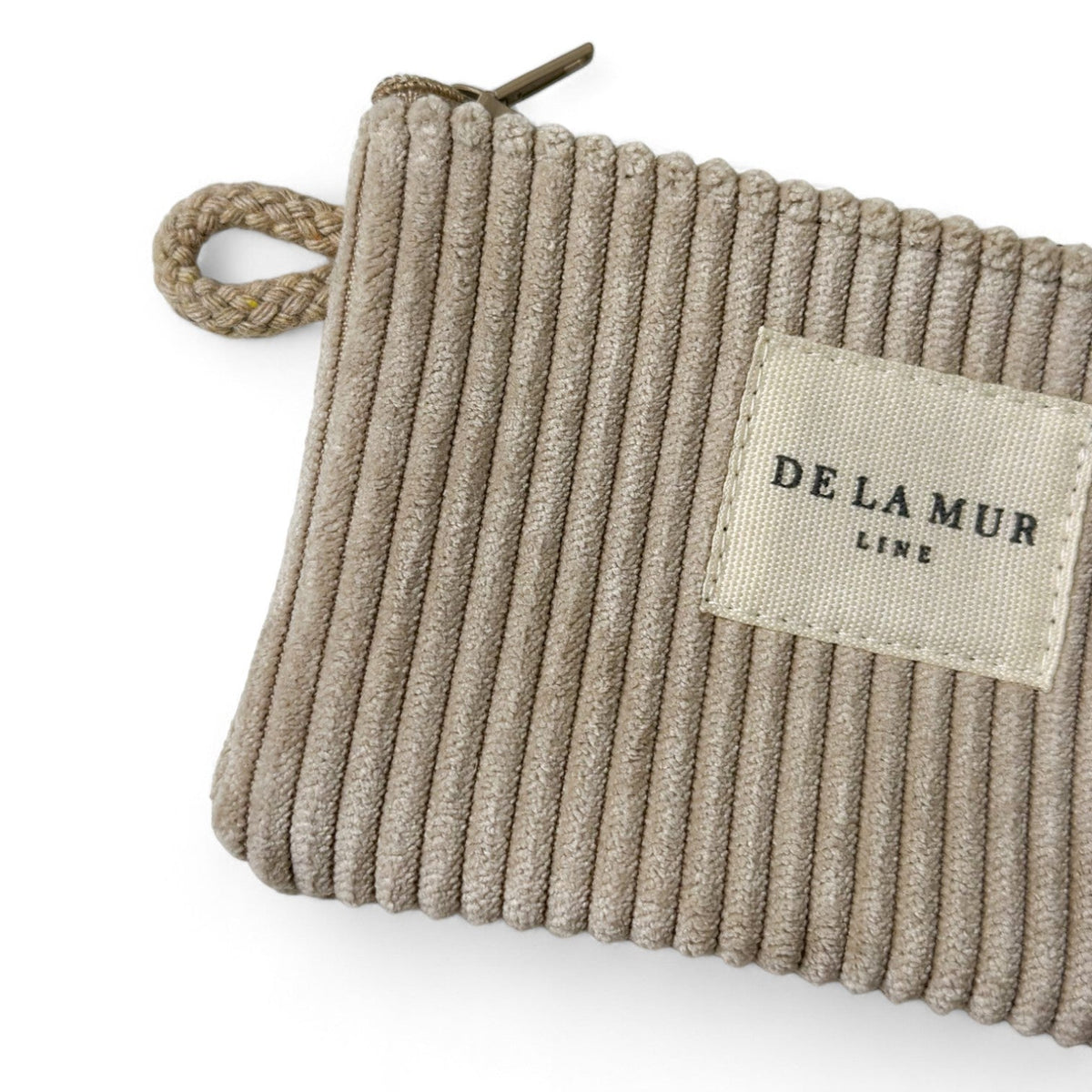 Close-up of DE LA MUR coin purse corduroy texture and woven Line label
