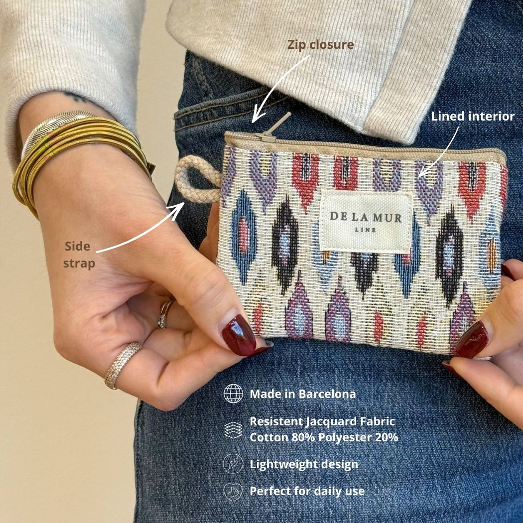 Model holding DE LA MUR Urban coin purse showing side strap, zip and lined interior