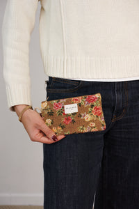 Model holding DE LA MUR mustard rose floral coin purse at the hip, lifestyle shot