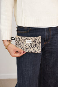 Model holding the beige and black leopard jacquard DE LA MUR Koto makeup bag, lifestyle shot