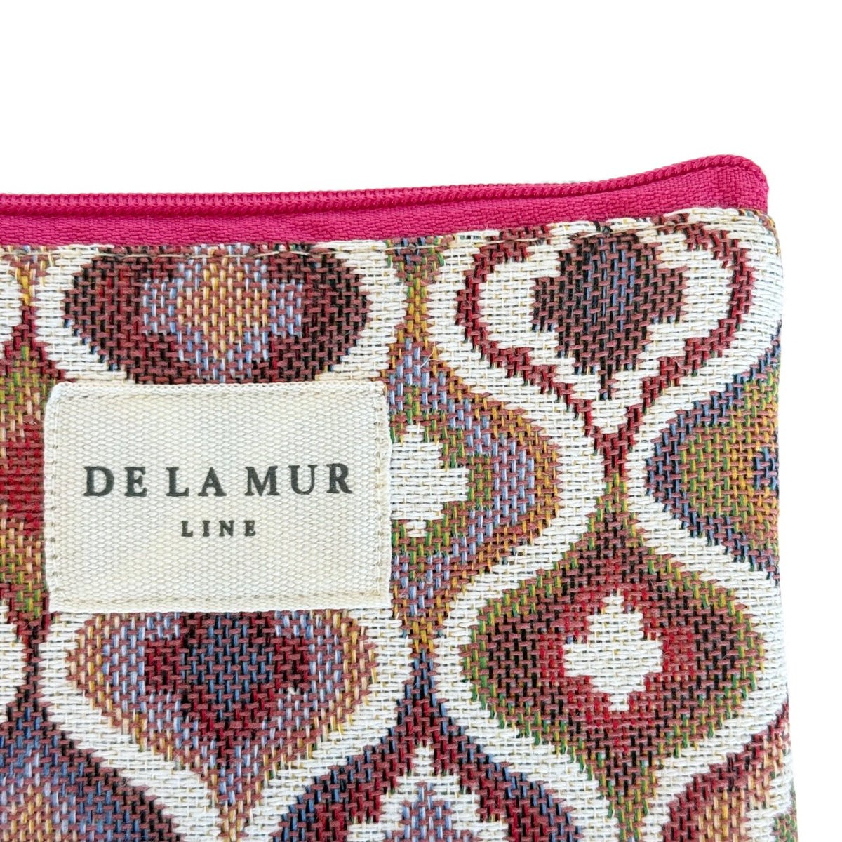 Close-up of DE LA MUR Line label on the Onda ogee-print jacquard bag corner