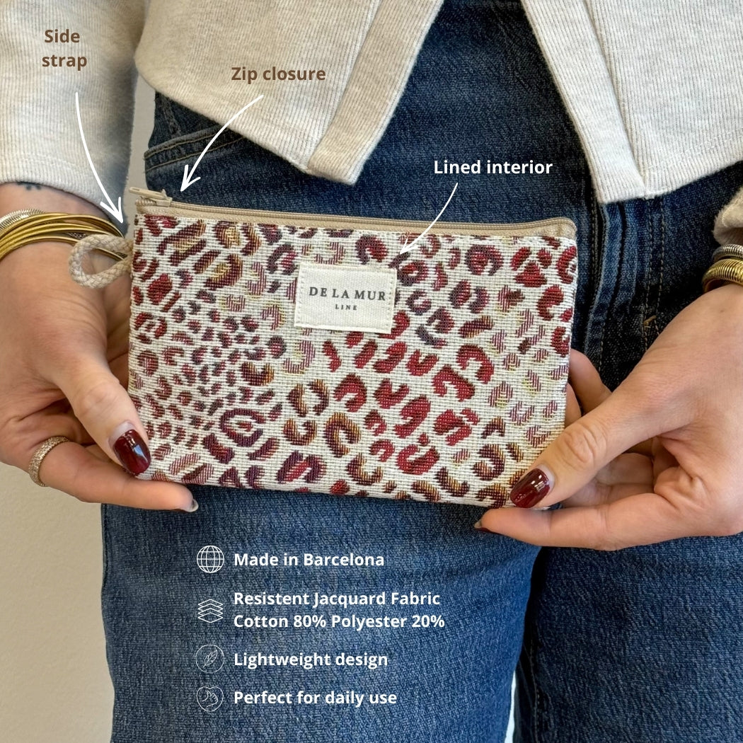 Hands holding DE LA MUR Talco leopard pouch, infographic of strap, zip and interior