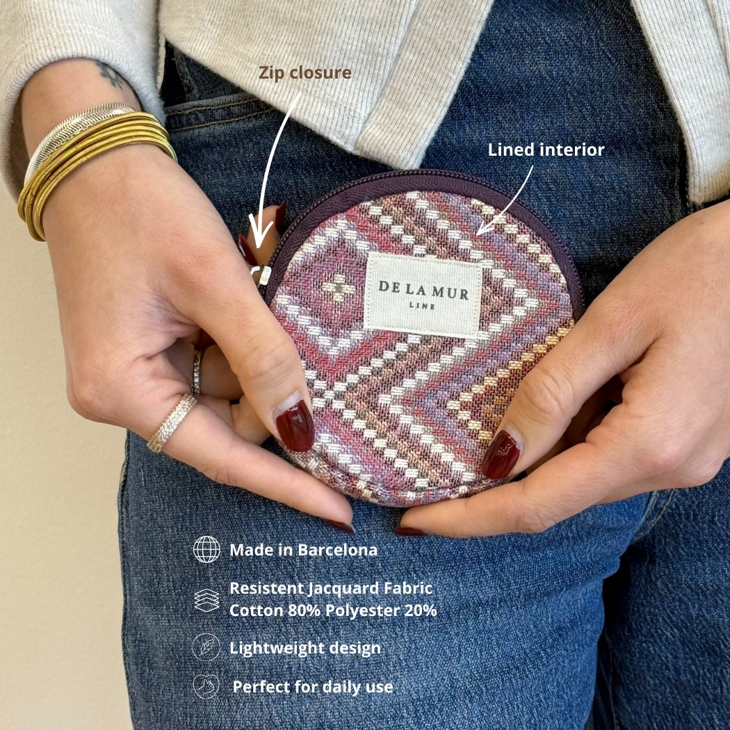 Model holding DE LA MUR Nana round coin purse, zip and lined interior labeled