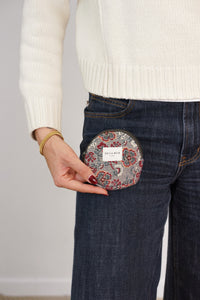Model holding the DE LA MUR floral jacquard round coin purse at the jeans pocket, lifestyle shot