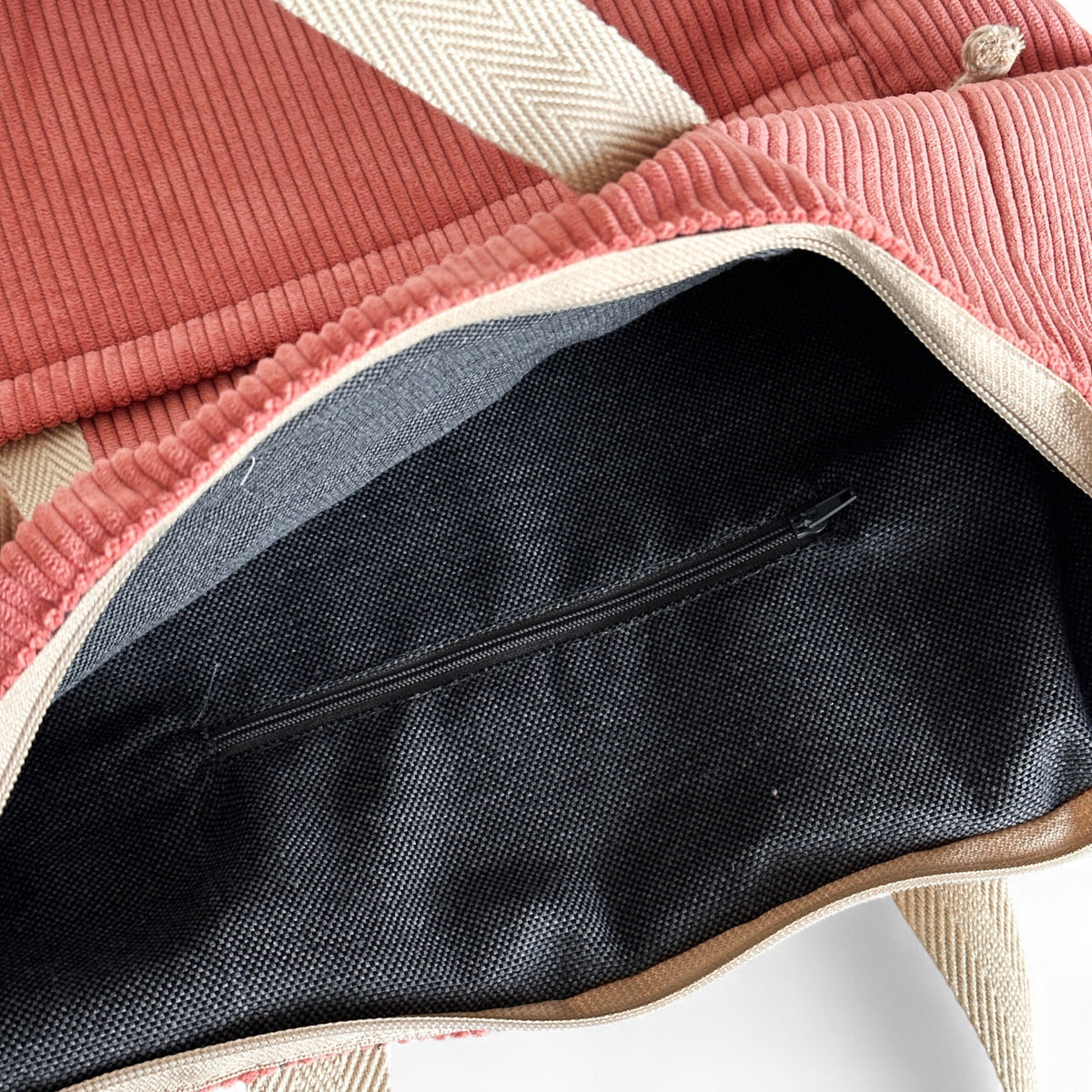 Open DE LA MUR coral corduroy backpack showing the lined interior zip pocket
