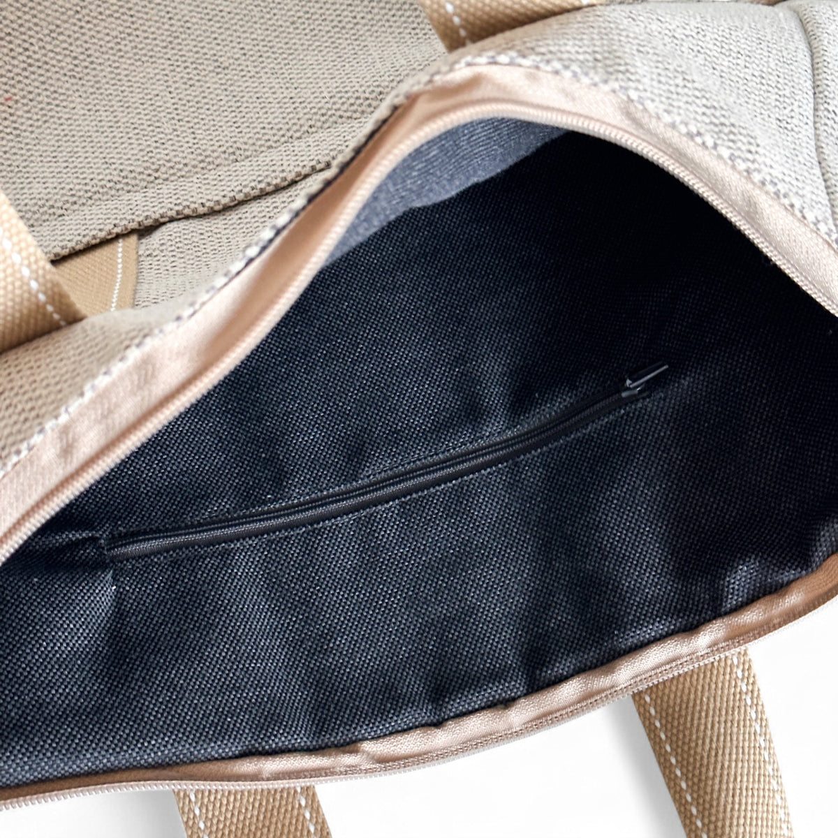 Open DE LA MUR Sydney backpack showing the dark lined interior with zip pocket