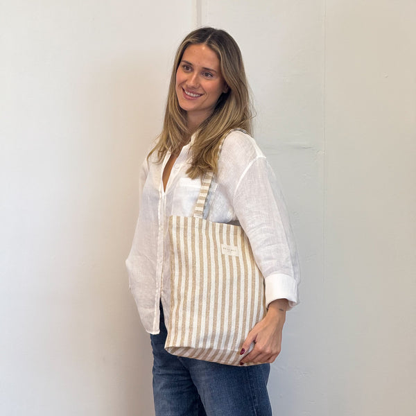 Model with the DE LA MUR Striped Medium Zippered Tote Bag – Beige & Gold (Lumos)