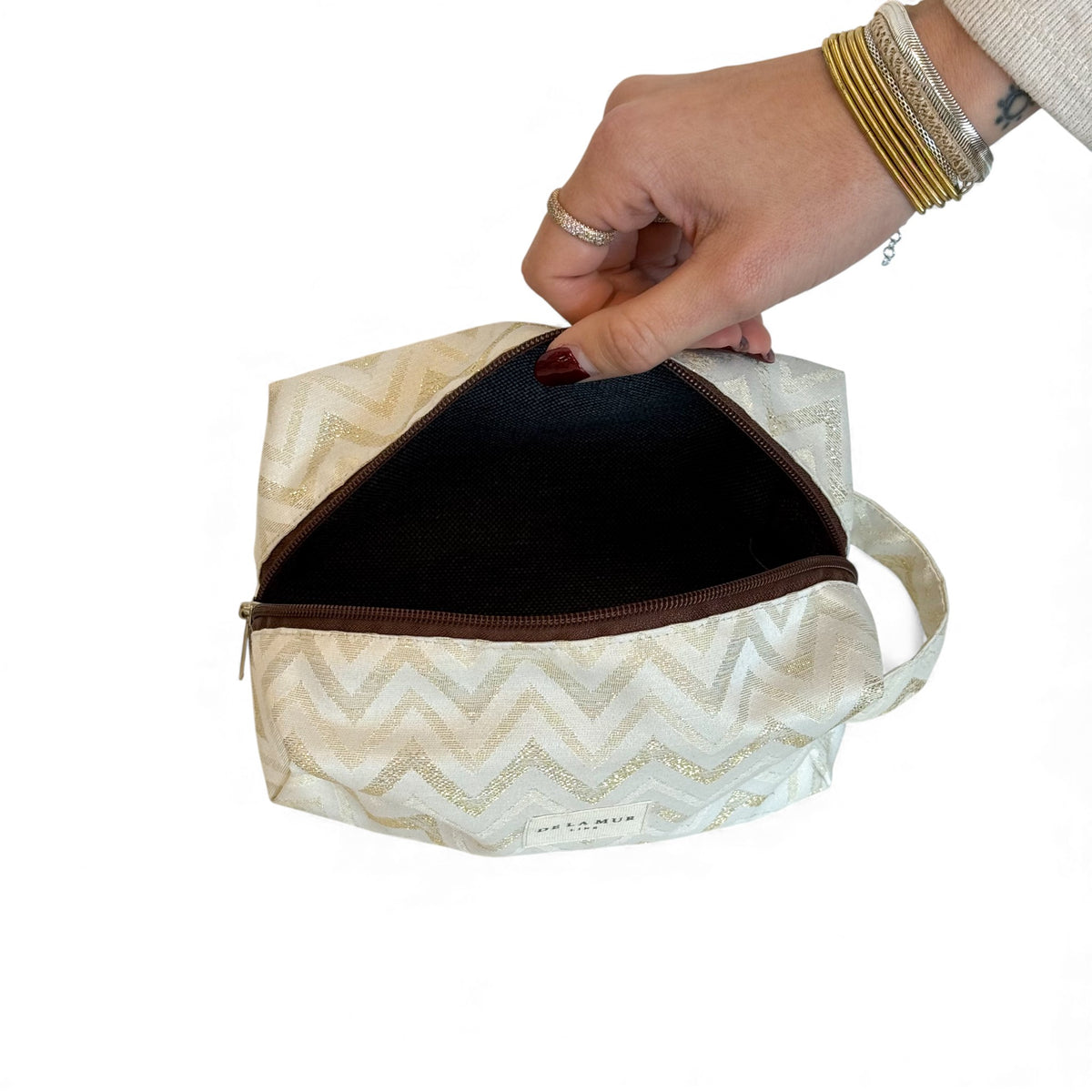 Open DE LA MUR Zigzag makeup bag showing the dark lined interior