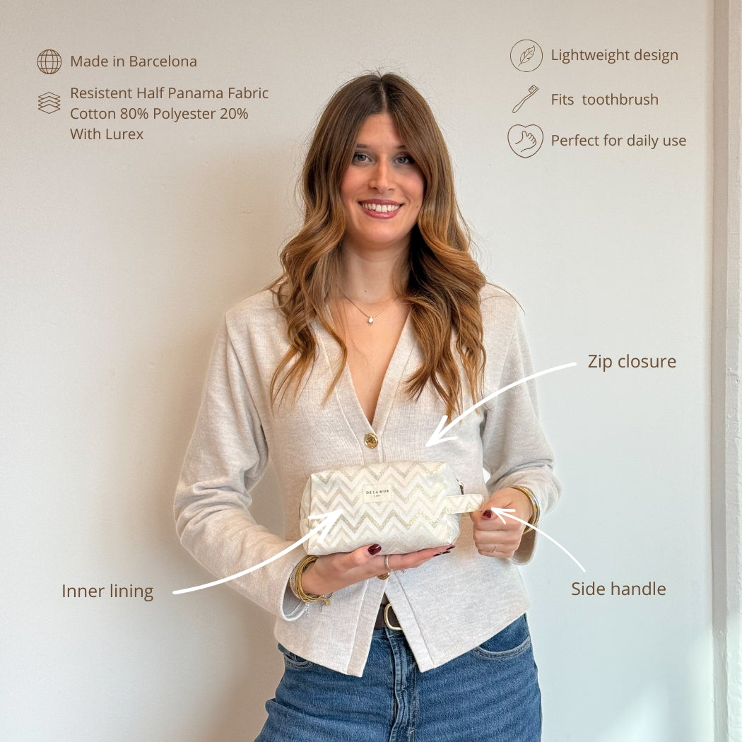 Model holding the DE LA MUR Zigzag makeup bag with feature callouts