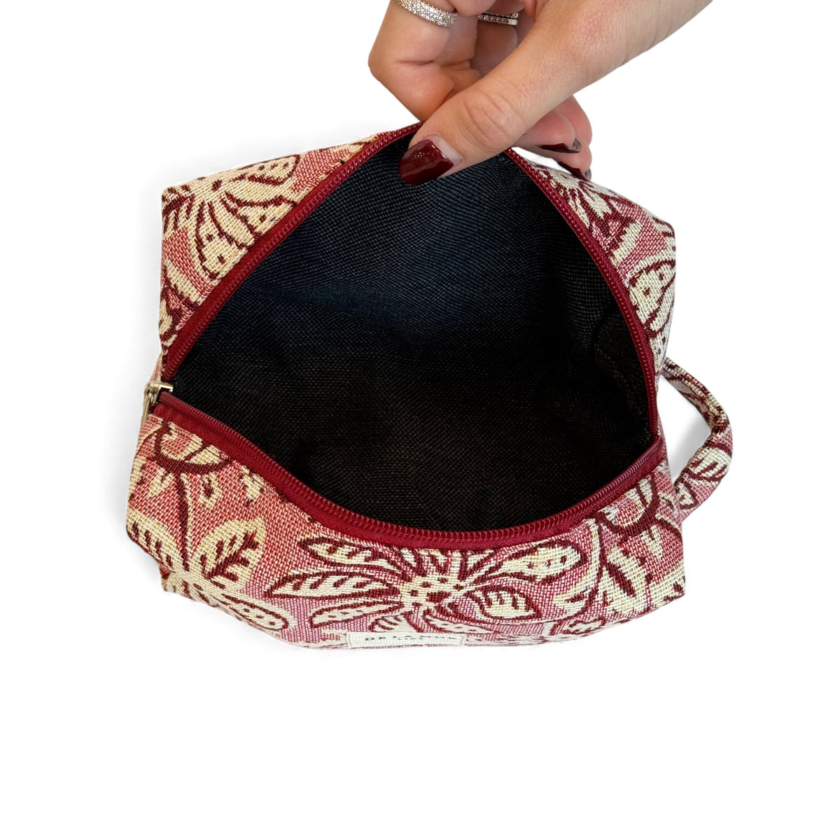 Open DE LA MUR floral makeup bag showing the dark lined interior
