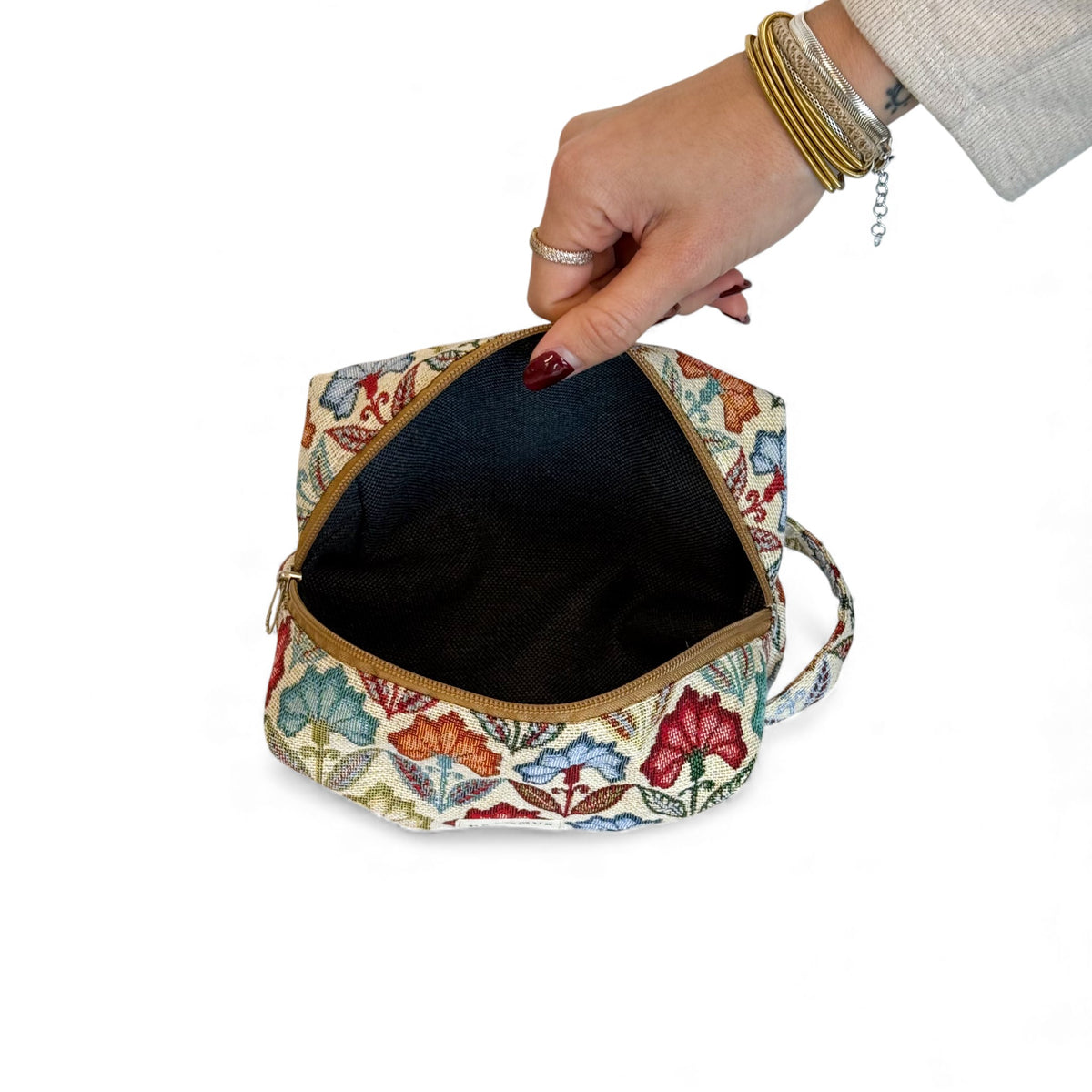 Open DE LA MUR multicolor floral makeup bag showing the dark lined interior