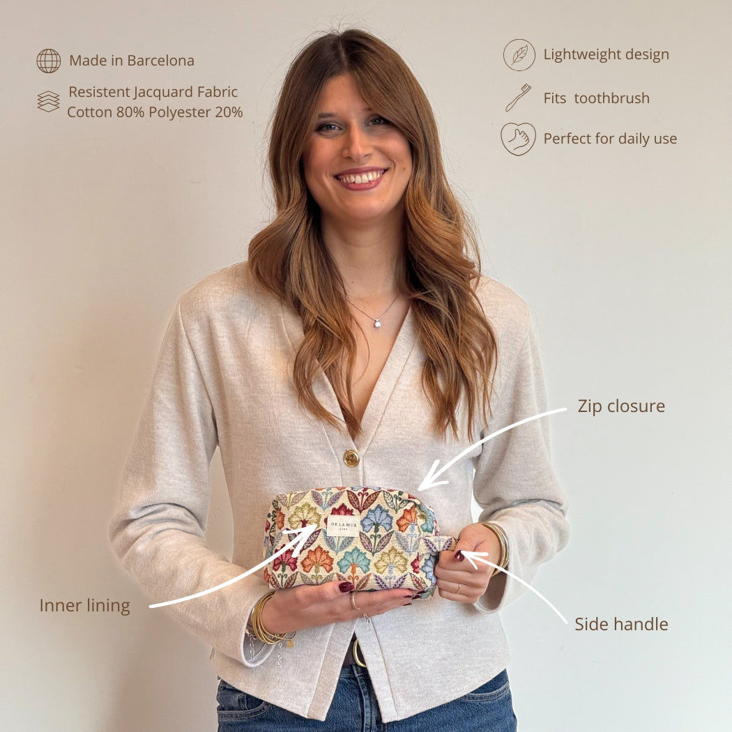 Model holding the multicolor floral DE LA MUR makeup bag with feature callouts