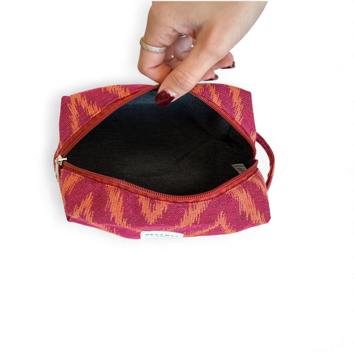 Open DE LA MUR Fuego makeup bag showing the dark lined interior