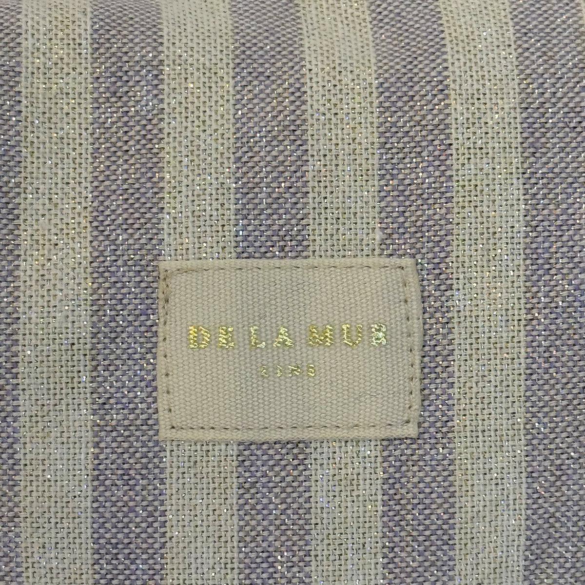 Close-up of the lilac lurex striped fabric and DE LA MUR Line label, Lulil