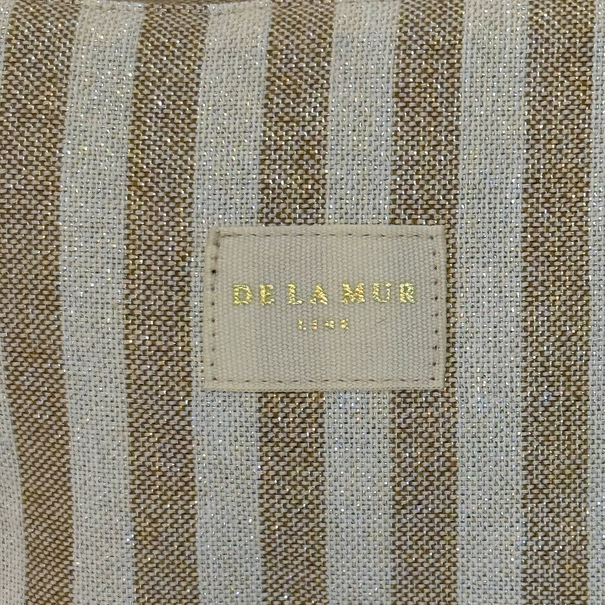 Close-up of the mustard lurex striped fabric and DE LA MUR Line label, Lumos