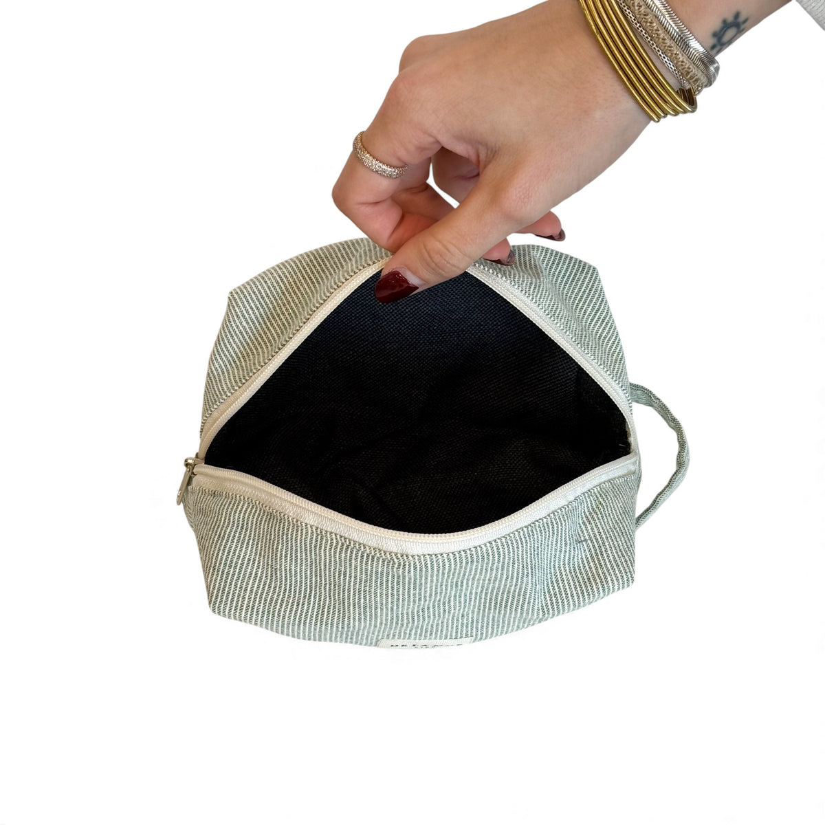 Open DE LA MUR Teo striped makeup bag showing the dark lined interior