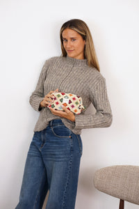 Woman holding DE LA MUR Zac geometric jacquard squared makeup bag, lifestyle shot