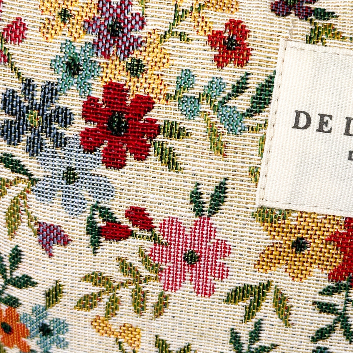 Close-up of the multicolor floral jacquard weave and DE LA MUR Line label