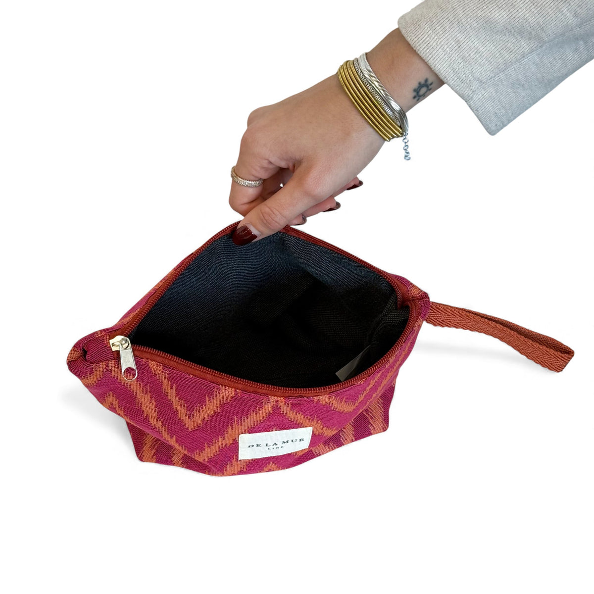 Open DE LA MUR Fuego makeup bag showing the black lined interior
