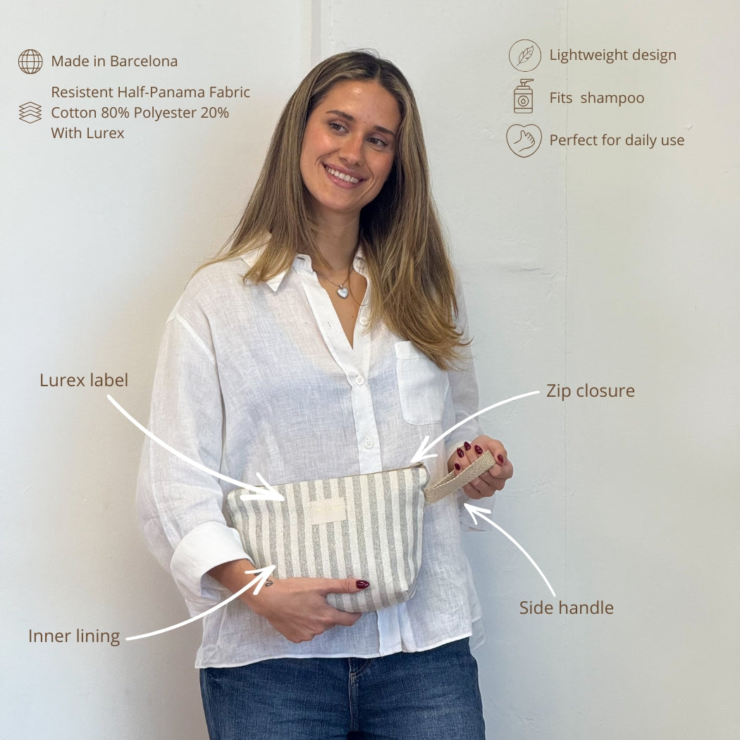 Model holding the DE LA MUR Lugris striped makeup bag with labeled features infographic
