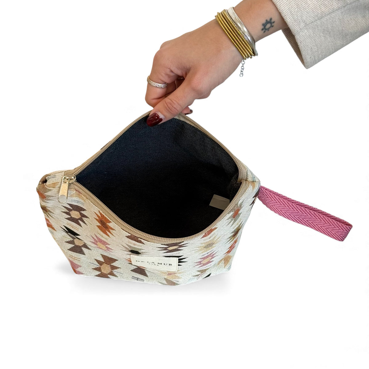 Open DE LA MUR geometric makeup bag showing the dark lined interior