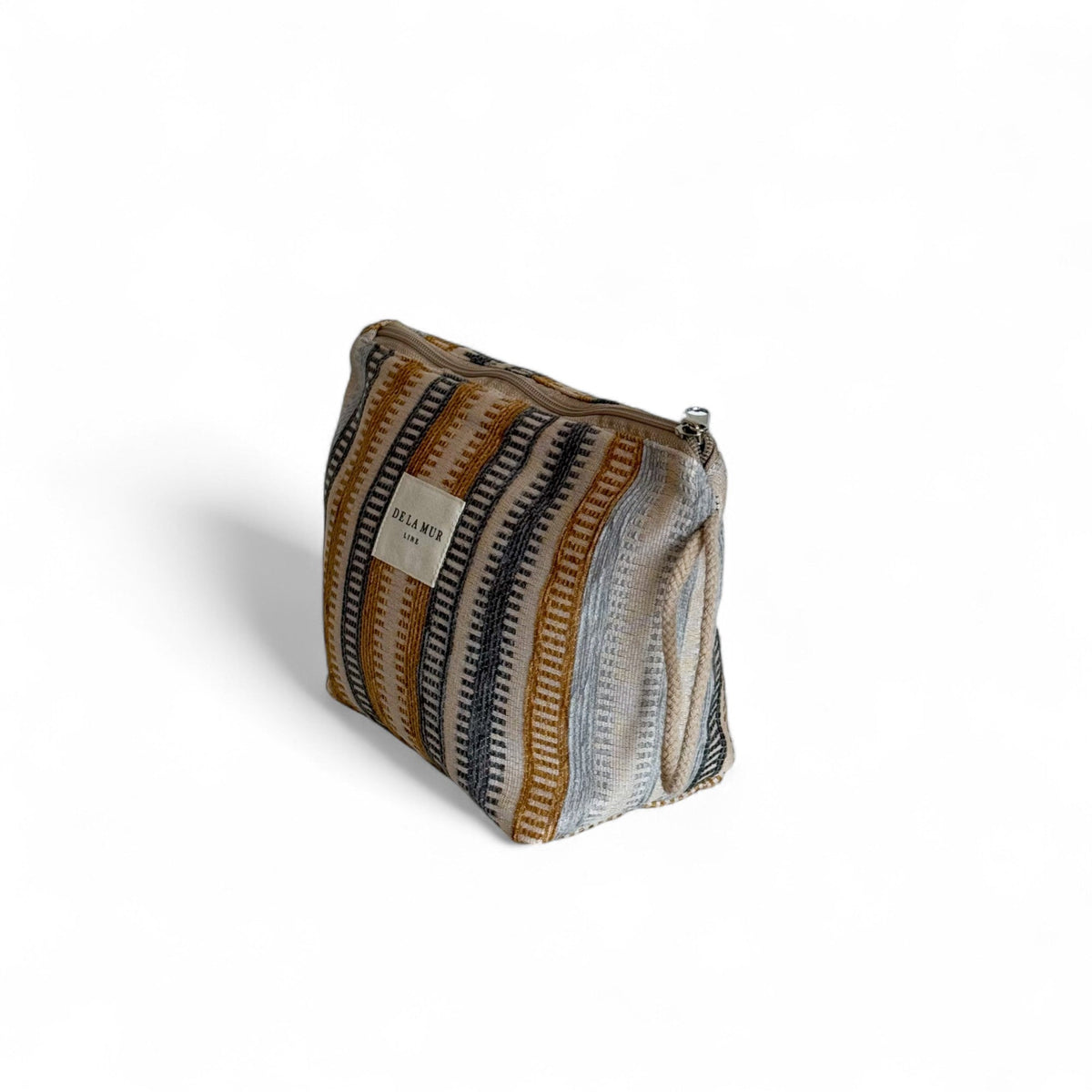 Three-quarter view of the striped jacquard Tron pouch by DE LA MUR